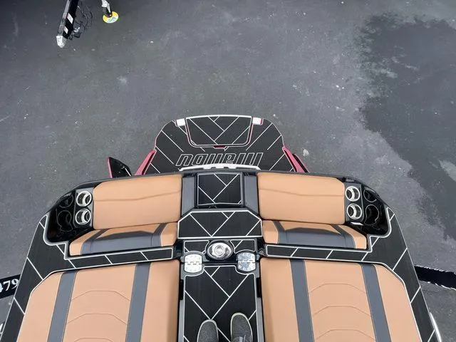 Slide: The Image of 2024 Malibu 23LSV boat interior with tan seats and cup holders. - 9