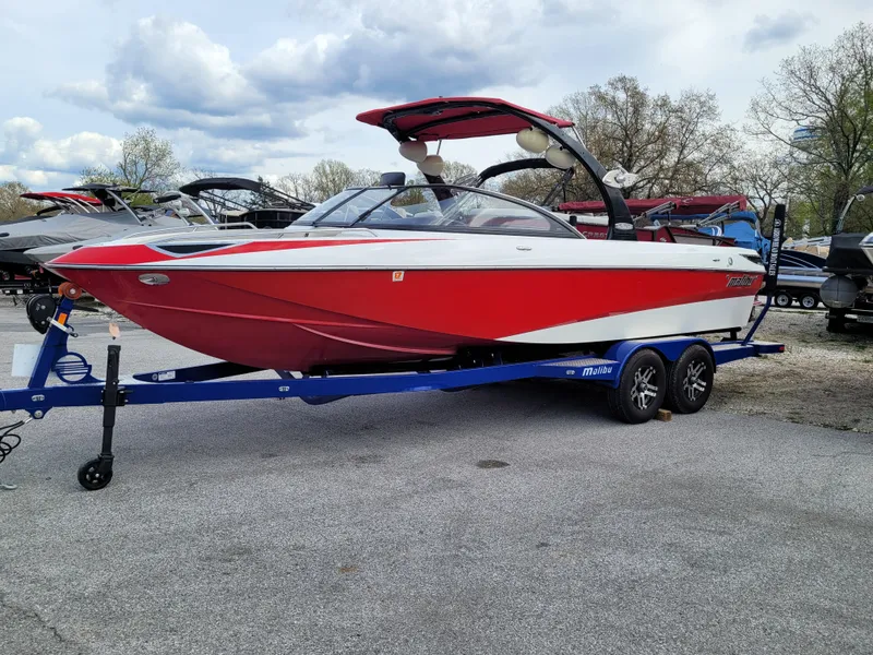 Slide: The Image of 2007 Malibu 247 Wakesetter boat on trailer, red and white design, parked outdoors. - 2