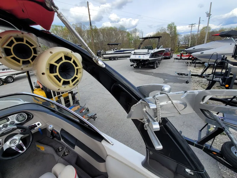 Slide: The Image of 2007 Malibu 247 Wakesetter interior with speakers and dashboard, parked among other boats. - 7