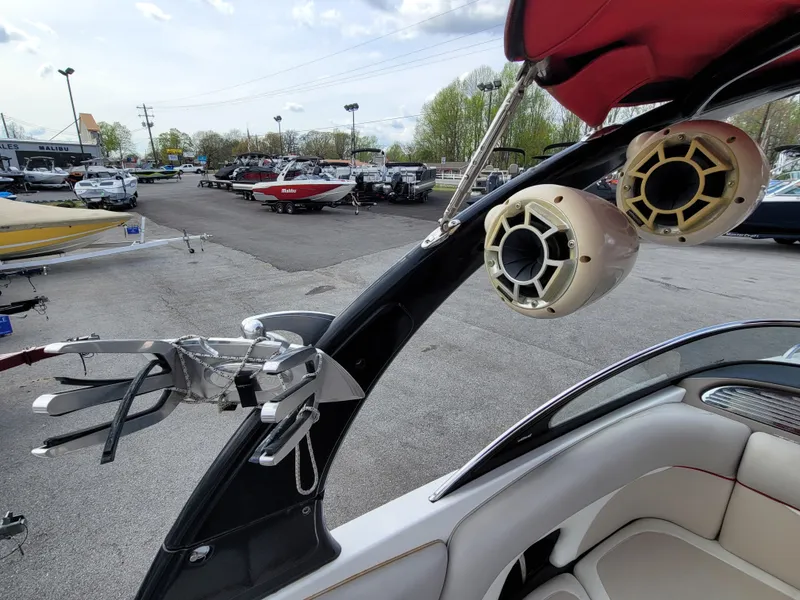 Slide: The Image of 2007 Malibu 247 Wakesetter boat with speakers and wakeboard rack in a dealership lot. - 8