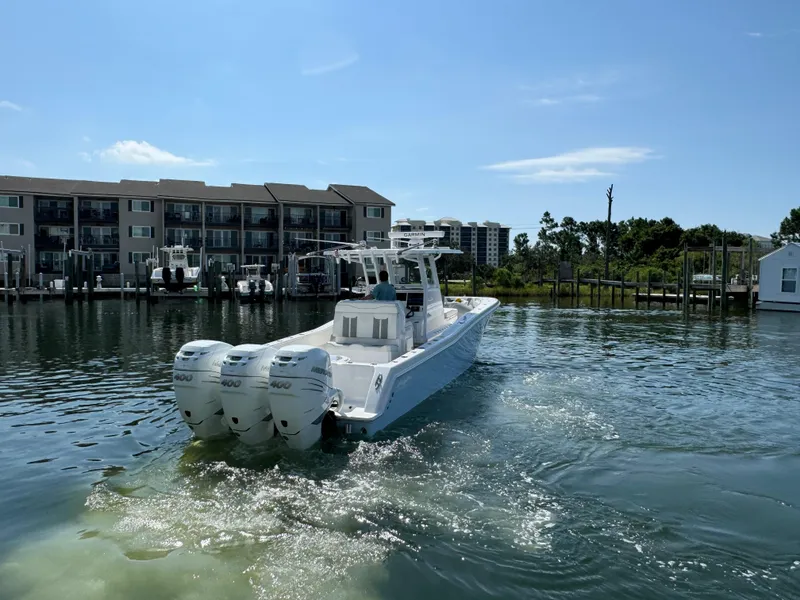 Slide: The Image of 2023 Invincible 36 Open Fisherman boat on calm water near docks. - 16