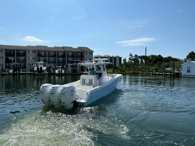 Slide: The Image of 2023 Invincible 36 Open Fisherman boat on water near docks and buildings. - 17