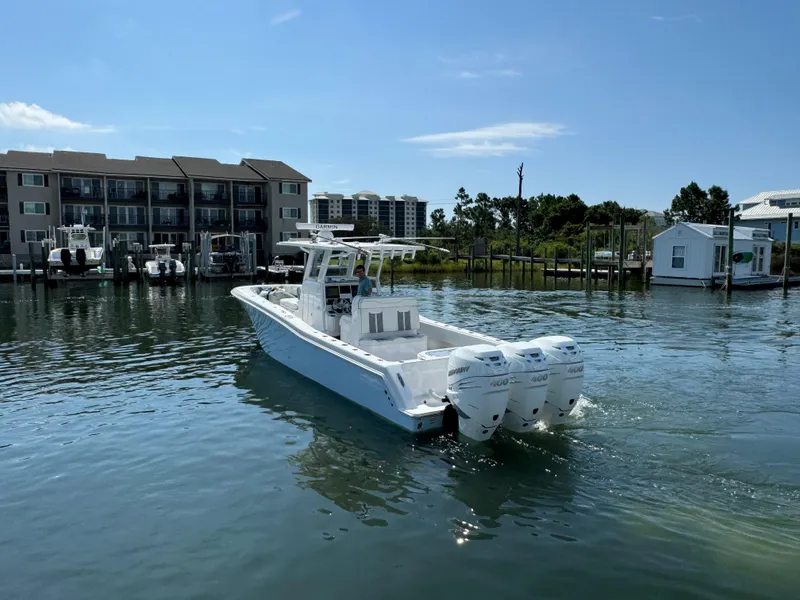 Slide: The Image of 2023 Invincible 36 Open Fisherman boat on calm water near docks. - 23