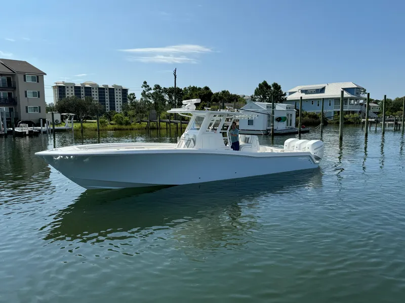 Slide: The Image of 2023 Invincible 36 Open Fisherman boat on calm water near waterfront homes. - 3