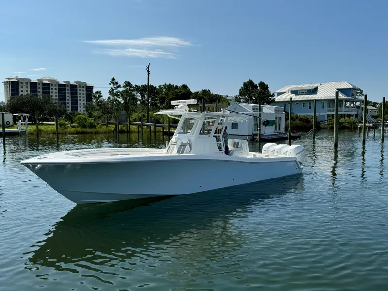 Slide: The Image of 2023 Invincible 36 Open Fisherman boat on calm water near docks and houses. - 4
