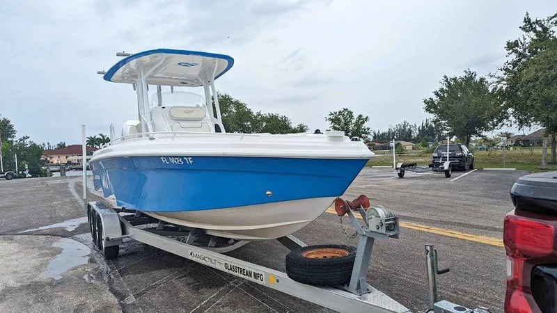 The Image of 2022 Glasstream 280 Pro-XS boat on trailer, blue and white design, parked outdoors. - 1