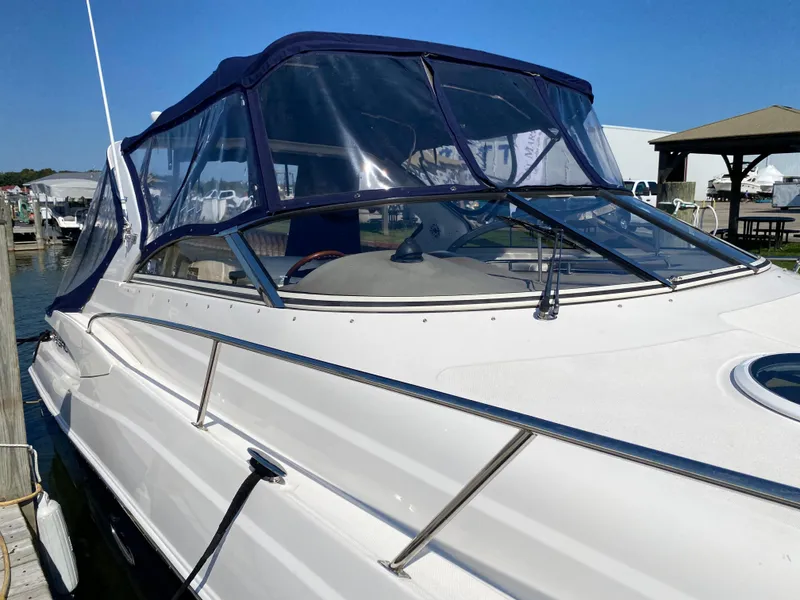 Slide: The Image of 2006 Regal 3560 Commodore yacht with blue canopy docked at marina. - 12