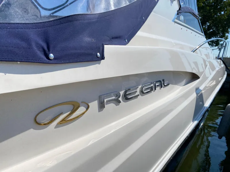 Slide: The Image of 2006 Regal 3560 Commodore boat side view with logo and water reflection. - 14