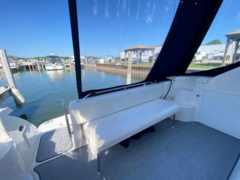 Slide: The Image of 2006 Regal 3560 Commodore boat interior with white seating and marina view. - 15