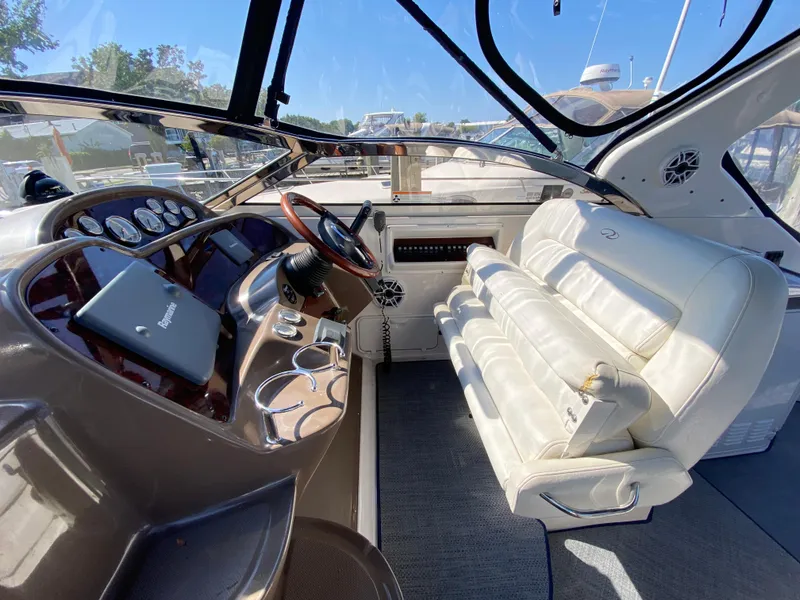 Slide: The Image of Interior of 2006 Regal 3560 Commodore yacht with white leather seating and control panel. - 19