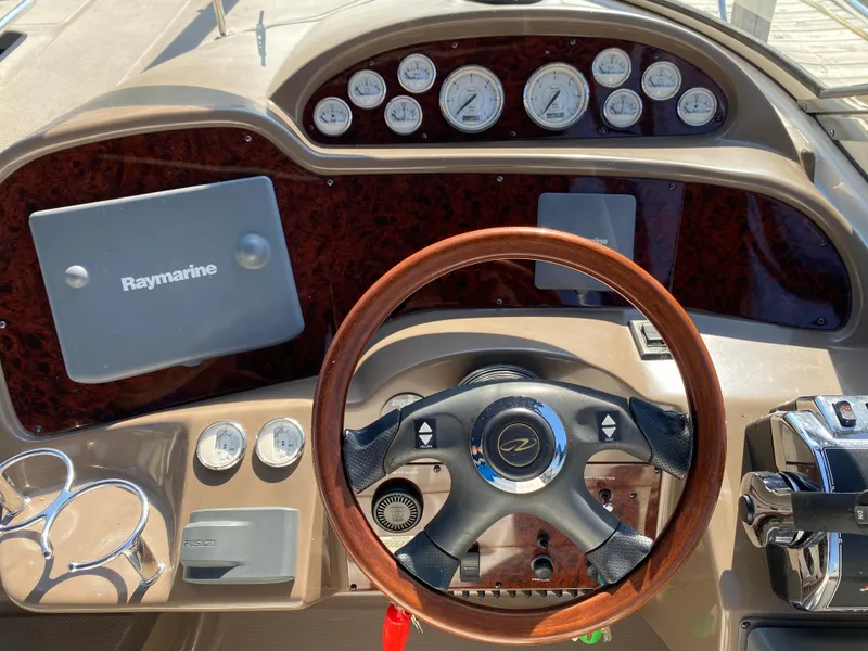 Slide: The Image of 2006 Regal 3560 Commodore dashboard with wood steering wheel and Raymarine navigation system. - 20