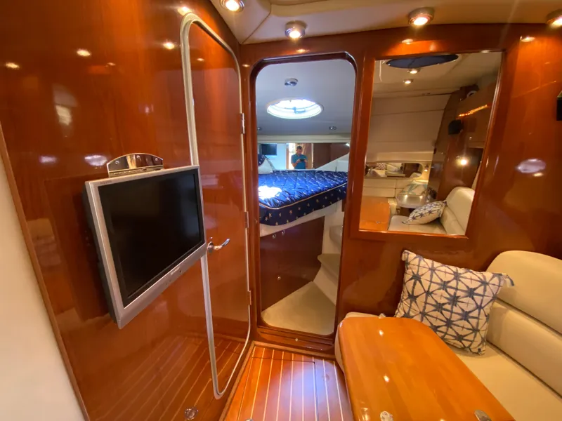 Slide: The Image of Interior of 2006 Regal 3560 Commodore yacht with wood finish and cozy seating area. - 27