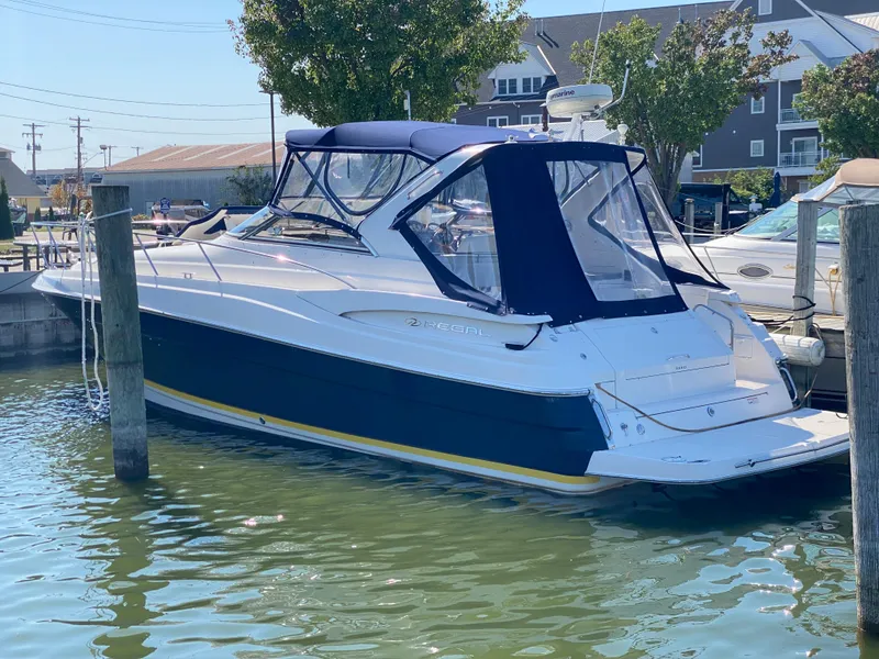 Slide: The Image of 2006 Regal 3560 Commodore yacht docked in marina, featuring blue and white design. - 5