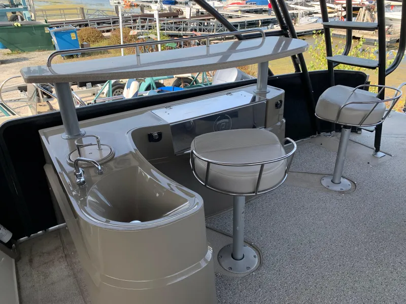 Slide: The Image of 2013 Premier 310 Boundary Waters Sky Dek boat interior with bar and swivel chairs. - 15