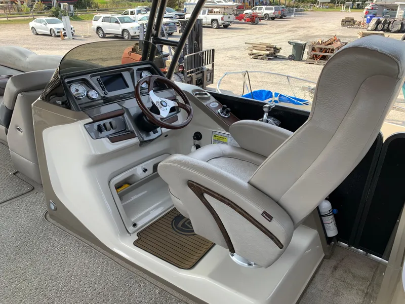 Slide: The Image of 2013 Premier 310 Boundary Waters Sky Dek boat cockpit with steering wheel and captain's chair. - 18