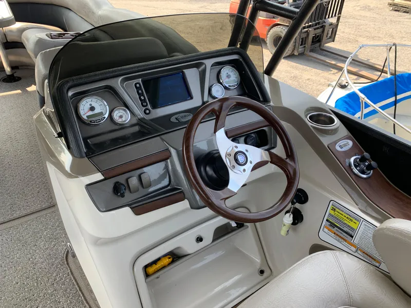 Slide: The Image of 2013 Premier 310 Boundary Waters Sky Dek boat dashboard with steering wheel and controls. - 19