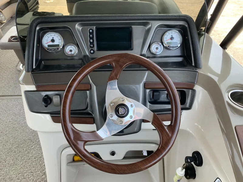 Slide: The Image of 2013 Premier 310 Boundary Waters Sky Dek dashboard with wood steering wheel and gauges. - 20