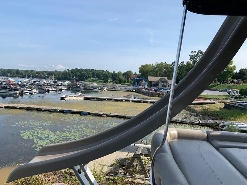 Slide: The Image of 2013 Premier 310 Boundary Waters Sky Dek with slide at scenic lakeside marina. - 29