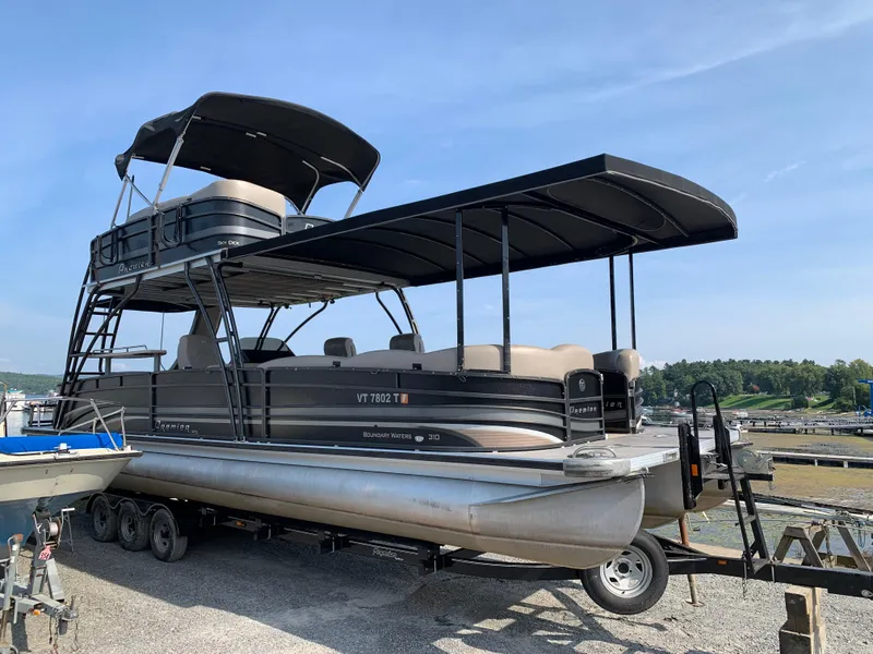 Slide: The Image of 2013 Premier 310 Boundary Waters Sky Dek pontoon boat on trailer, dockside view. - 38