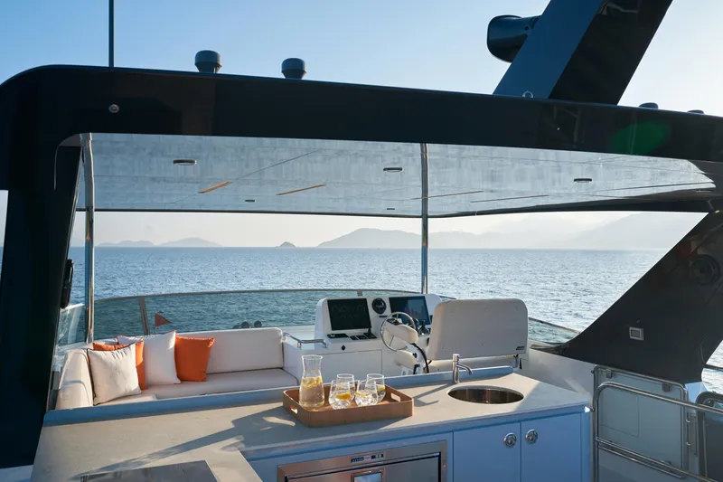 Slide: The Image of Luxurious 2024 CL Yachts CLB65 yacht deck with seating, ocean view, and refreshments. - 10