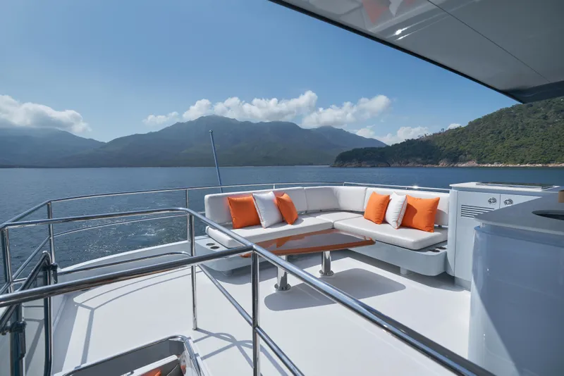 Slide: The Image of 2024 CL Yachts CLB65 yacht deck with seating, ocean view, and mountains in the background. - 13