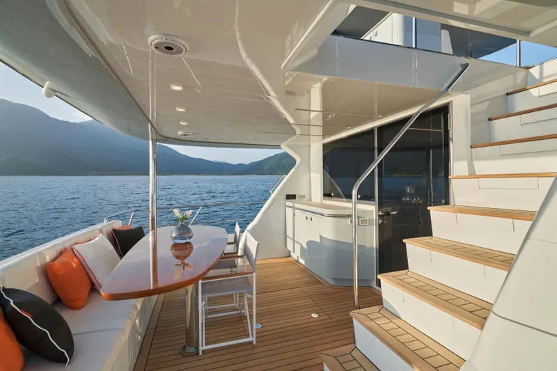 Slide: The Image of 2024 CL Yachts CLB65 luxury yacht deck with seating, table, and scenic ocean view. - 17