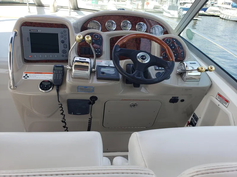 Slide: The Image of Helm of 2006 Sea Ray 320 Sundancer with gauges, steering wheel, and navigation equipment. - 12