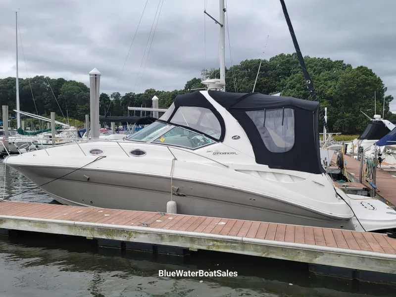 Slide: The Image of 2006 Sea Ray 320 Sundancer docked at marina, featuring sleek design and black canopy. - 2