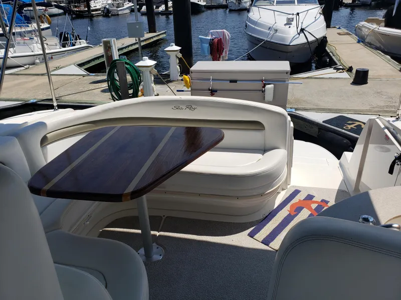 Slide: The Image of 2006 Sea Ray 320 Sundancer yacht with elegant seating and wooden table at marina. - 20