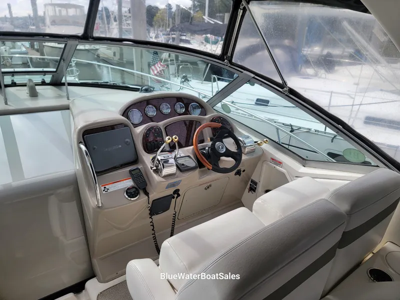 Slide: The Image of 2006 Sea Ray 320 Sundancer helm with steering wheel, gauges, and navigation equipment. - 21