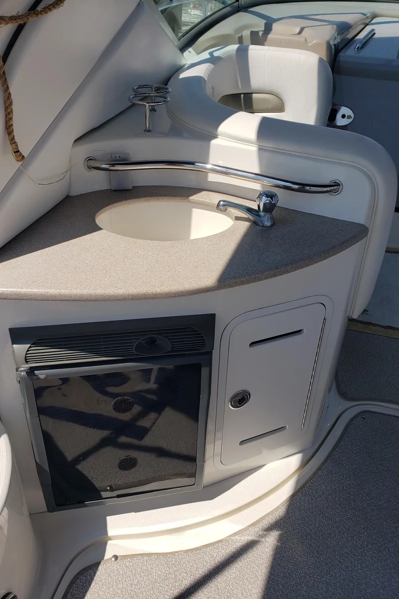 Slide: The Image of 2006 Sea Ray 320 Sundancer boat interior with sink and storage cabinets. - 23