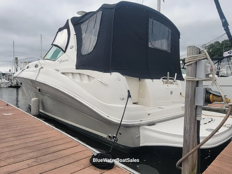 Slide: The Image of 2006 Sea Ray 320 Sundancer docked with black canopy, overcast sky. - 3