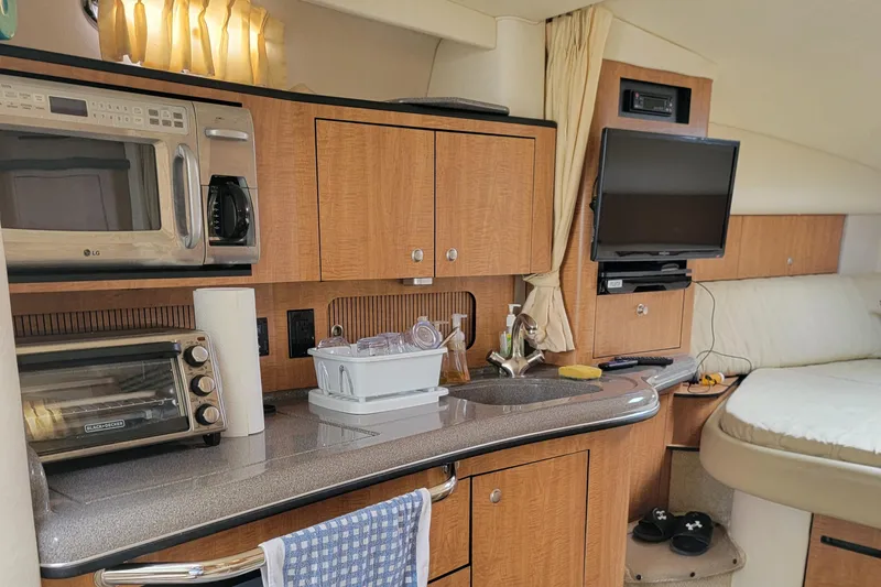 Slide: The Image of Interior of 2006 Sea Ray 320 Sundancer with kitchenette and cozy sleeping area. - 32