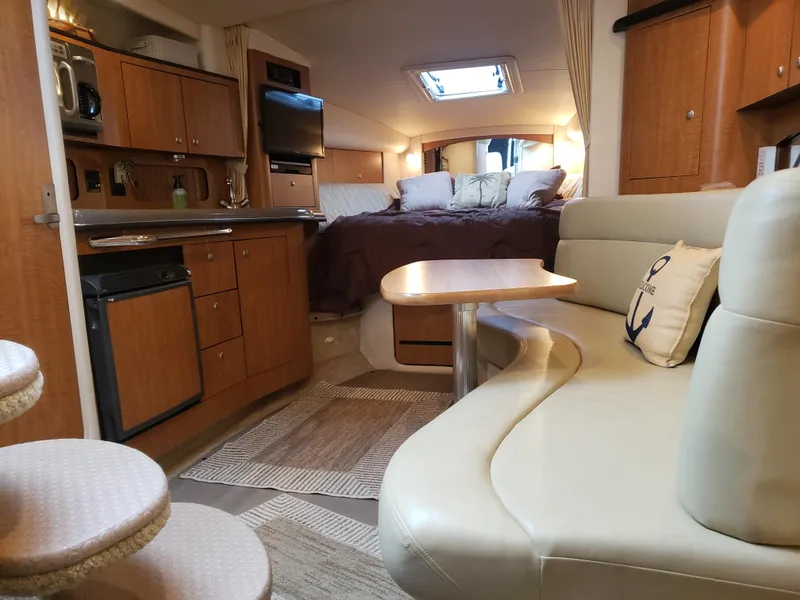 Slide: The Image of Interior of 2006 Sea Ray 320 Sundancer yacht with cozy seating and kitchenette. - 33