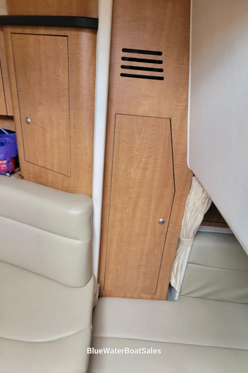 Slide: The Image of Interior of 2006 Sea Ray 320 Sundancer with wood paneling and beige seating. - 37