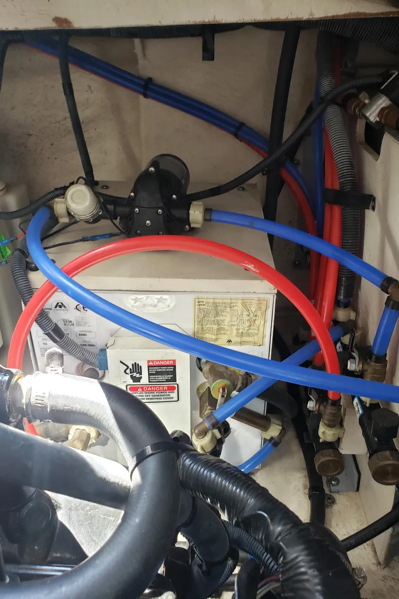 Slide: The Image of Engine compartment of a 2006 Sea Ray 320 Sundancer with visible hoses and wiring. - 46