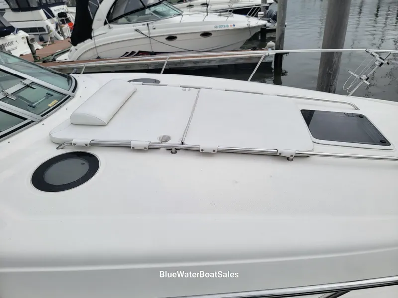 Slide: The Image of 2006 Sea Ray 320 Sundancer boat deck with sunpad and hatch, docked at marina. - 8