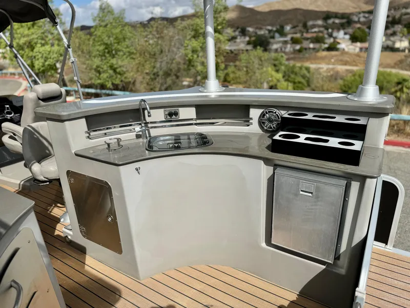 Slide: The Image of 2019 Premier Accolade 310 boat kitchen with sink, storage, and beverage holders. - 15