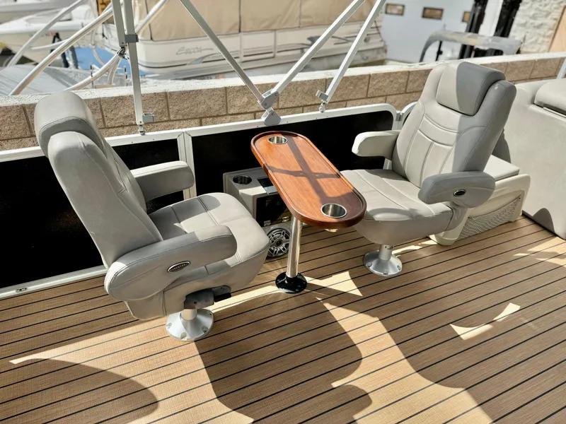 Slide: The Image of Premier Accolade 310 boat interior with two swivel chairs and a wooden table, 2019 model. - 19
