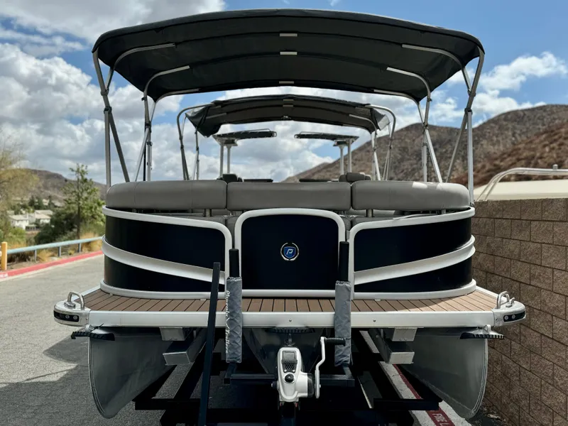 Slide: The Image of 2019 Premier Accolade 310 pontoon boat on trailer, scenic mountain backdrop. - 2