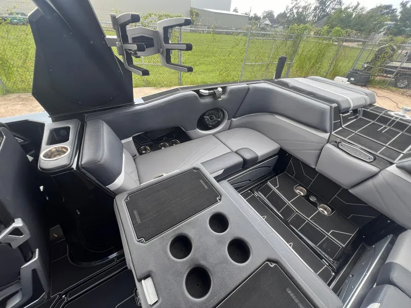 Slide: The Image of 2023 Supra SL 450 boat interior with gray seating and cup holders. - 10
