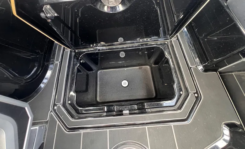 Slide: The Image of 2023 Supra SL 450 boat storage compartment with sleek black interior design. - 11