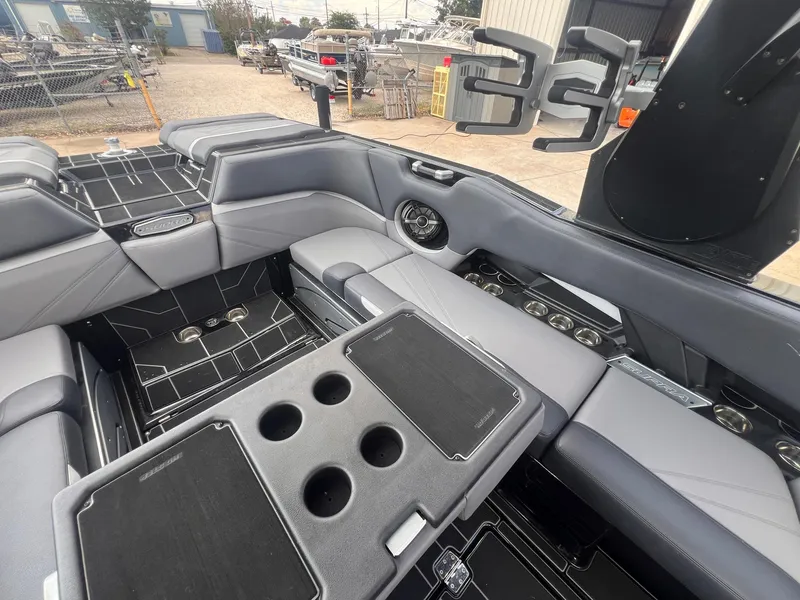 Slide: The Image of 2023 Supra SL 450 boat interior with gray seating and cup holders. - 16