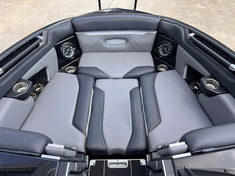 Slide: The Image of 2023 Supra SL 450 boat interior with gray and black seating, cup holders, and speakers. - 18