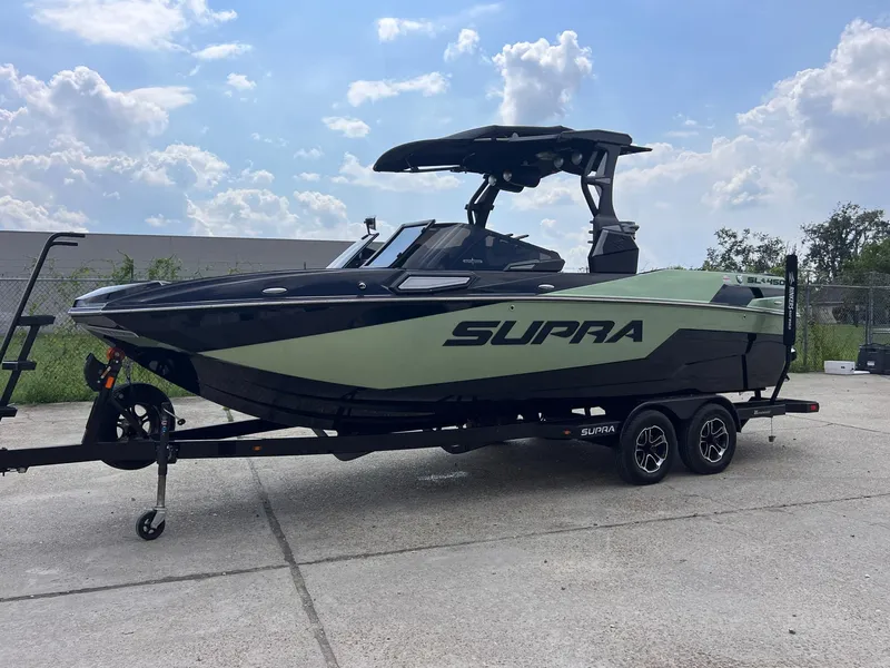 Slide: The Image of 2023 Supra SL 450 boat on trailer under cloudy sky. - 3