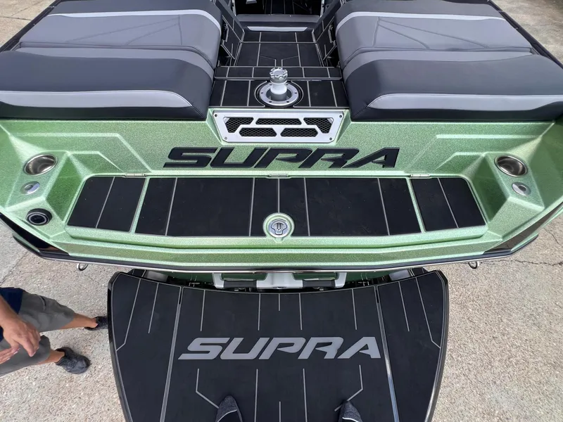 Slide: The Image of 2023 Supra SL 450 boat, green exterior, black seating, rear view. - 6