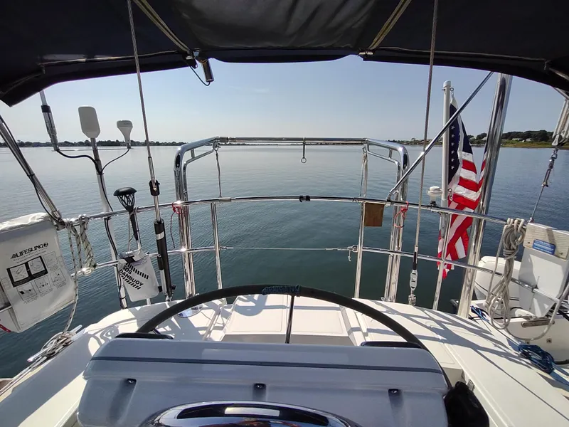 Slide: The Image of Cockpit view of 2007 Outbound 46 sailboat with American flag on calm water. - 13