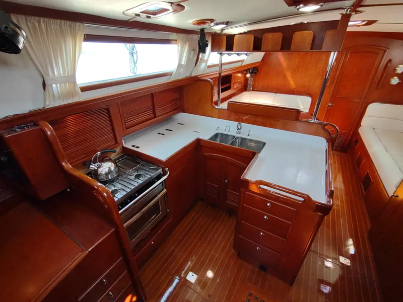 Slide: The Image of Luxurious 2007 Outbound 46 yacht interior with modern kitchen and wooden cabinetry. - 26