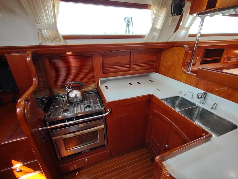 Slide: The Image of Luxurious 2007 Outbound 46 yacht kitchen with stove, sink, and wooden cabinetry. - 27