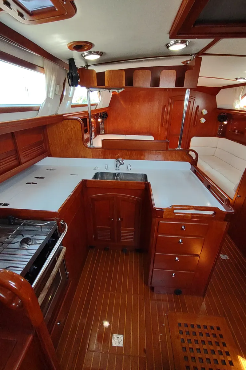 Slide: The Image of Luxurious 2007 Outbound 46 yacht interior with wooden cabinetry and modern kitchen amenities. - 28